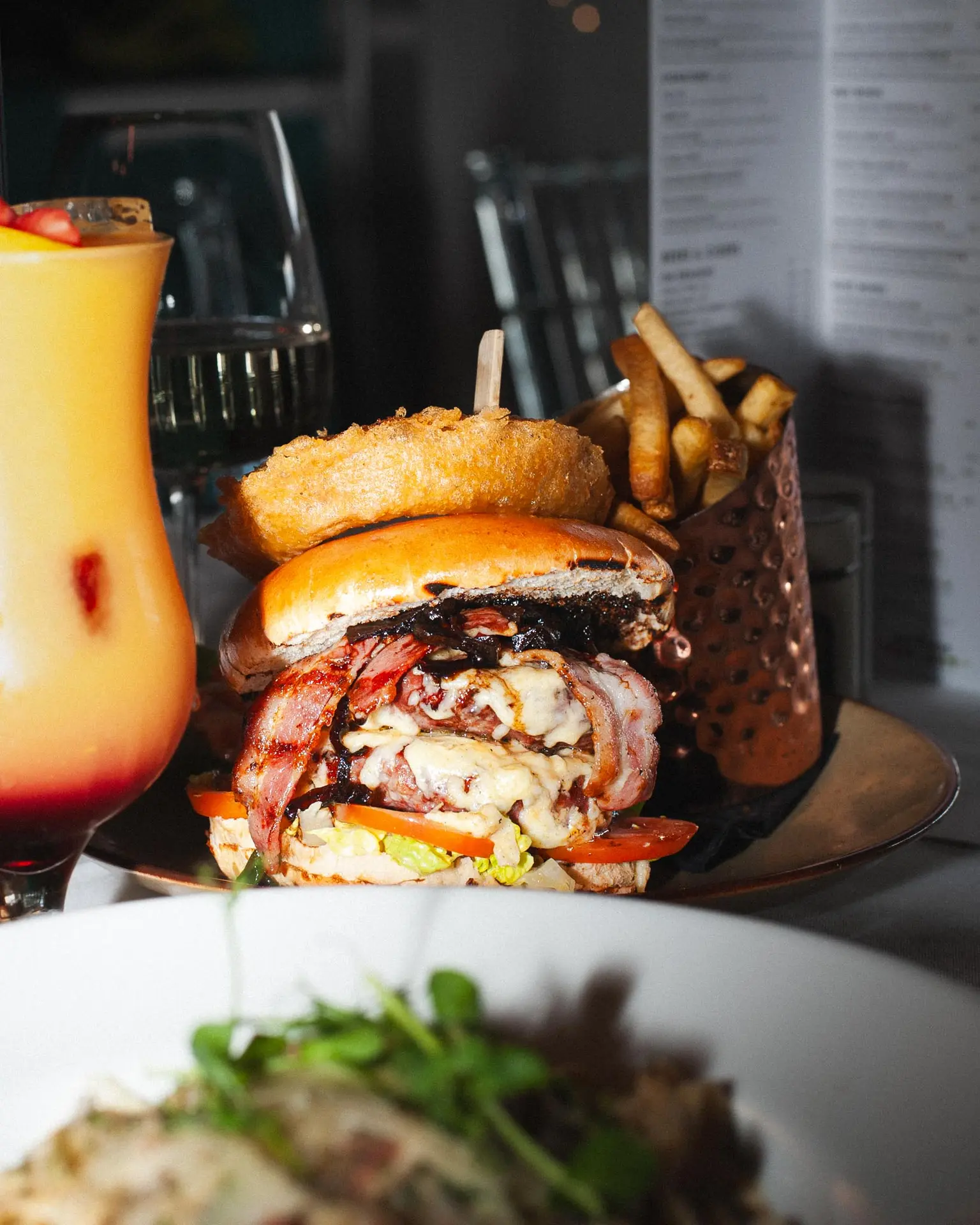 A burger, fries and cocktail served at Casa