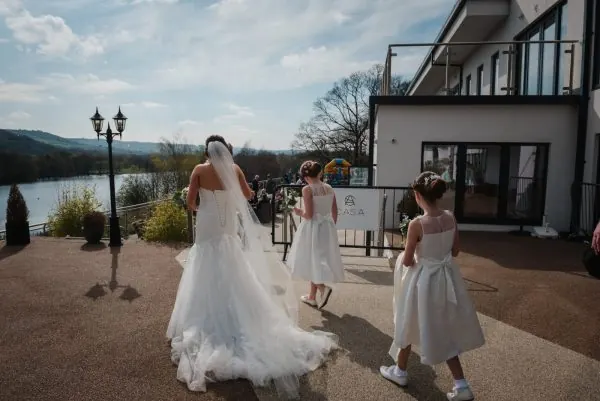 A bride arriving at Casa beside the water with flower girls